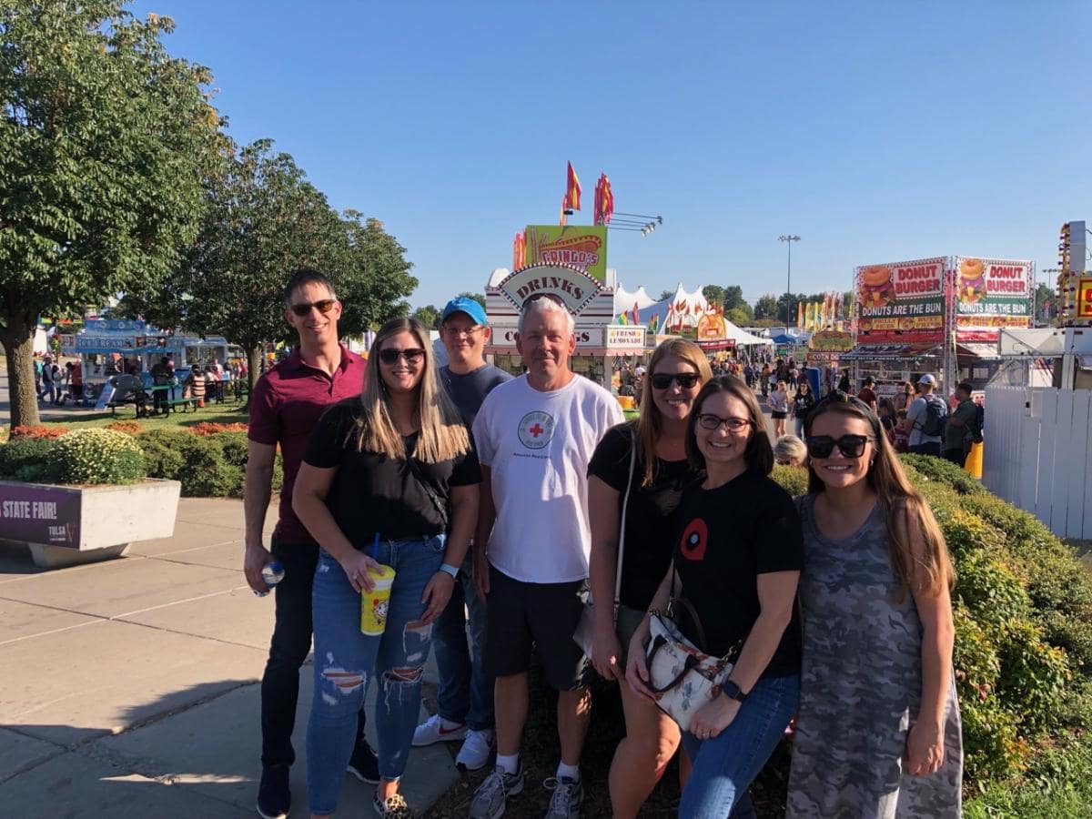 Smiling group posing at a state fair.