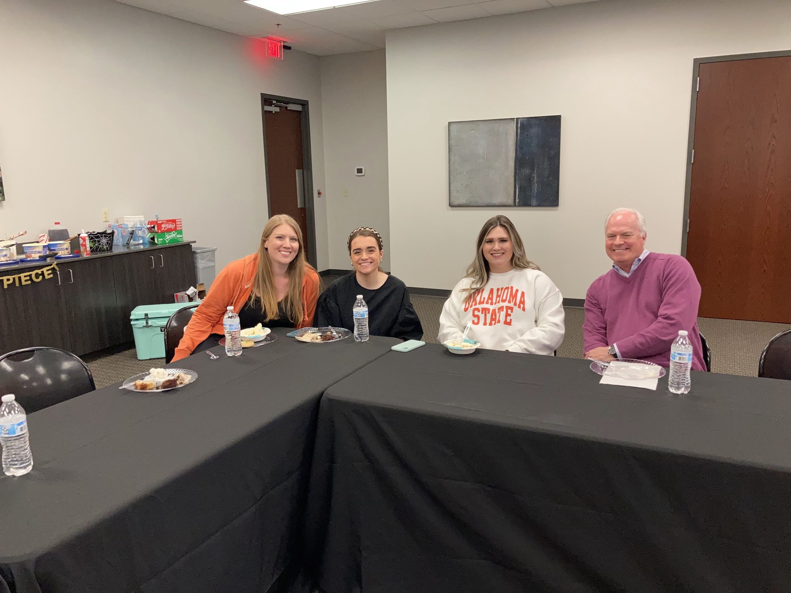 Kyle, Madison, Chelsea and Steve sitting at a table during an office event.
