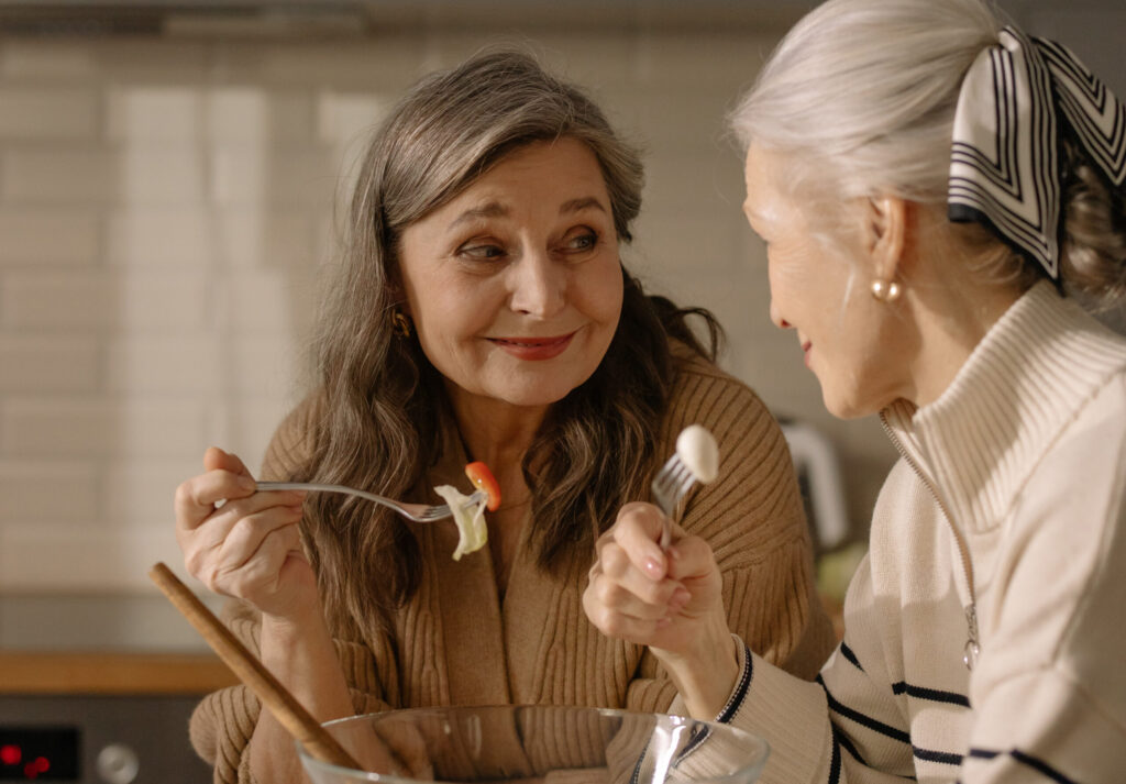 two elderly women having a conversation over dinner